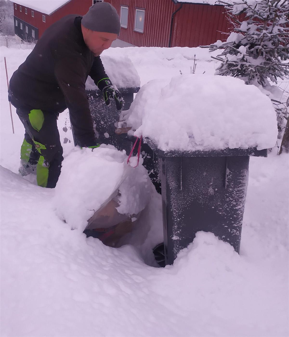 Renovatør strever med snødekte avfallsbeholdere - Klikk for stort bilde